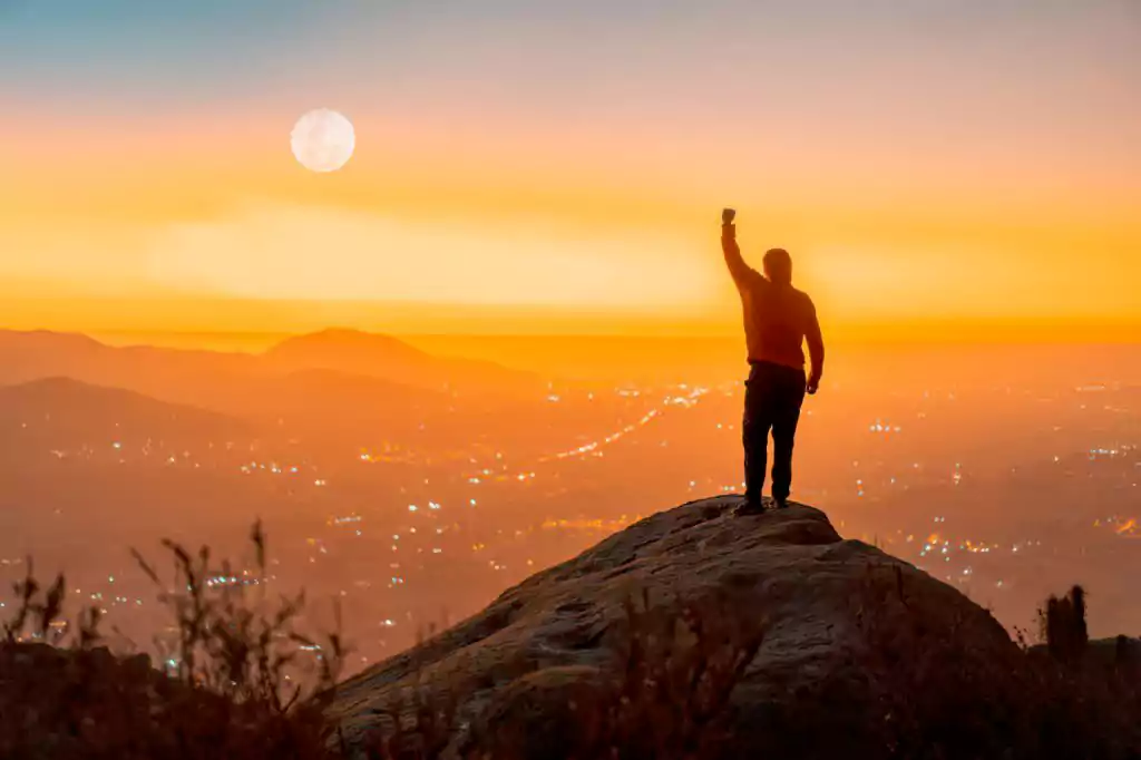man_raising_arm_after_reaching_the_top